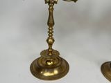 pair of antique brass candlesticks with candles on each of them