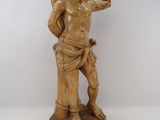 statue en bois sculpté représentant un homme tenant un oiseau dans la main