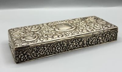 une boîte en argent dont le couvercle est orné d'un motif floral