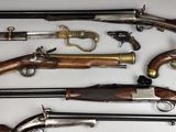 many different types of guns displayed on a table