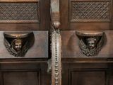 two wooden doors with carvings on them in a room