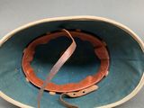 an image of a helmet with a leather strap on a gray surface
