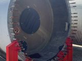 an image of a large metal pipe sitting on top of gravel