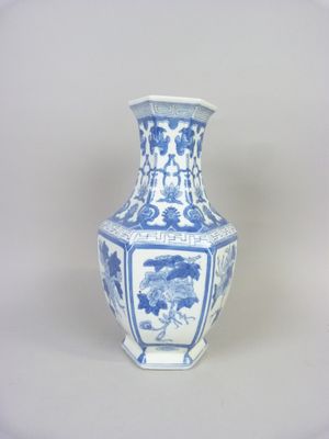 un vase bleu et blanc posé sur une surface blanche