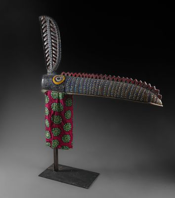 une sculpture en bois représentant un oiseau avec des plumes sur la tête