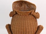 a basket with a frog on it sitting on the floor