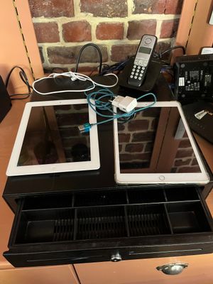 un bureau sur lequel se trouvent un téléphone, une tablette et d'autres appareils électroniques