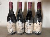 three bottles of wine are lined up on a shelf