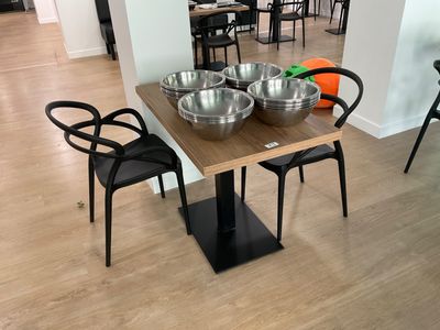 a table with bowls and chairs in the middle of the room