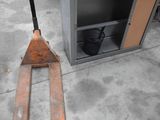 a fork lifter sitting next to a metal box