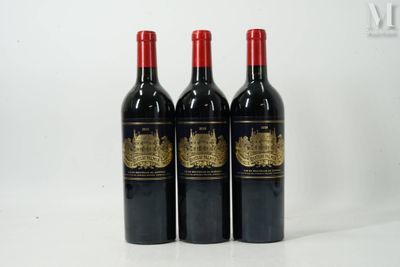 trois bouteilles de vin rouge sont alignées sur une surface blanche
