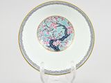 a chinese porcelain plate with a bird on a branch of a cherry tree