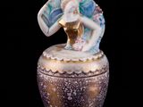 une boîte en verre surmontée d'une figurine