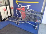 a shopping cart that is sitting in front of a sign