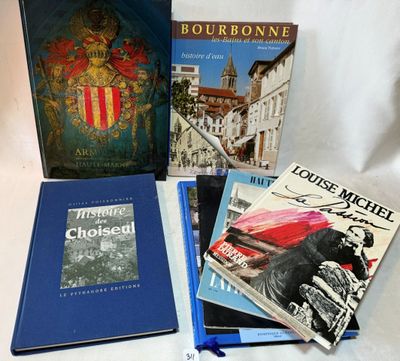 Plusieurs livres sont posés sur une table blanche, à côté d'un stylo bleu.