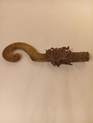 an antique brass hook with a dragon head on it