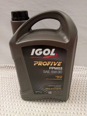 a close up of a bottle of engine oil on a table