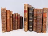 de nombreux livres anciens alignés sur une surface blanche