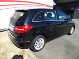 the back of a black mercedes b - class parked in front of a building