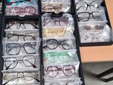 many pairs of glasses sitting on a table in a room