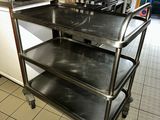 a kitchen with a stove, oven, and a cart in it