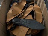many pairs of shoes in a cardboard box on the floor