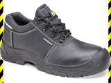 un gros plan sur une paire de chaussures de travail noires sur un fond rayé jaune et noir