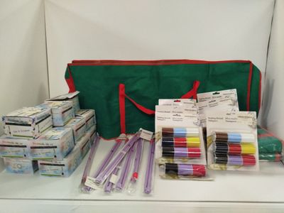 un sac vert rempli de fournitures posé sur une table blanche