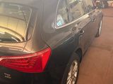 the back end of a black car parked in a garage