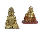 deux figurines en or représentant des bouddhas assis sur une surface blanche