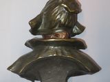 bronze statue of a monkey sitting on top of a pillow