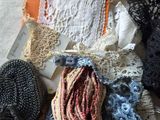 many different types of crochets and scarves laid out on a table