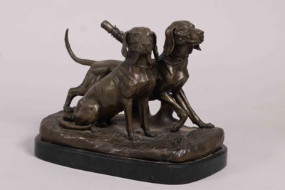 bronze statue of two dogs on a rock with a baseball bat in its mouth