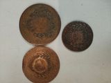 three different types of coins sitting on top of a white surface