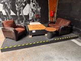 two chairs and a table in a room with a mural on the wall