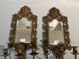 deux miroirs accrochés au mur à côté d'un lustre