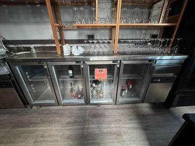 a bar with a lot of wine glasses on the shelves