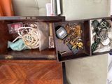 a wooden box with a bunch of jewelry inside of it