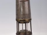 an old fashioned metal lantern with a light on top of it