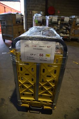 un chariot sur lequel est posée une caisse, dans un entrepôt