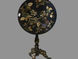 une image représentant une table noire et dorée ornée d'un motif floral