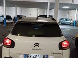 a white car parked in a parking lot with other cars