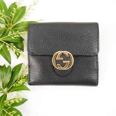 a black leather wallet with a gold ring on the front