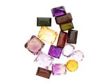 un tas de cubes de verre de différentes couleurs posés sur une surface blanche
