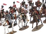 many figurines of men riding horses on a white surface