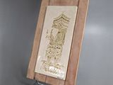 une photo d'une plaque en bois sur laquelle figure le portrait d'un homme