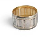 une image montrant un gros plan d'une bague en argent posée sur une surface blanche