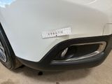 the front bumper of a white car with a sticker on it