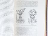 an open book with a drawing of a telescope on it