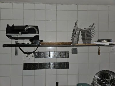 un mur carrelé de blanc, avec une étagère et un ventilateur